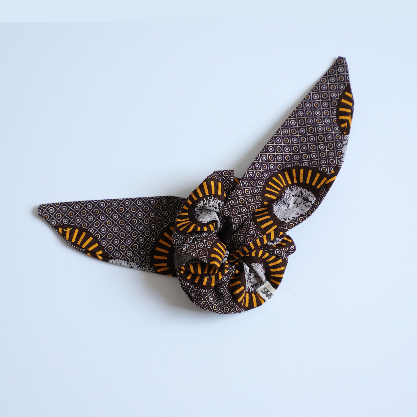 Chouchou marron imprimé lion avec petit foulard-cravate (amovible) sur fond blanc